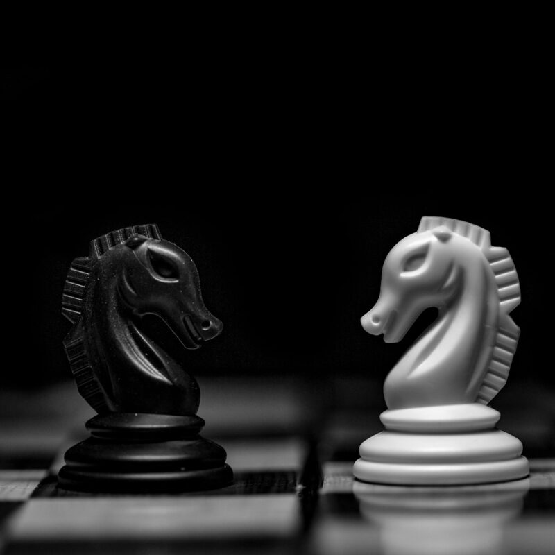 Chess pieces on a dark board, representing the difference between fixed automation rules and AI agents making bounded decisions