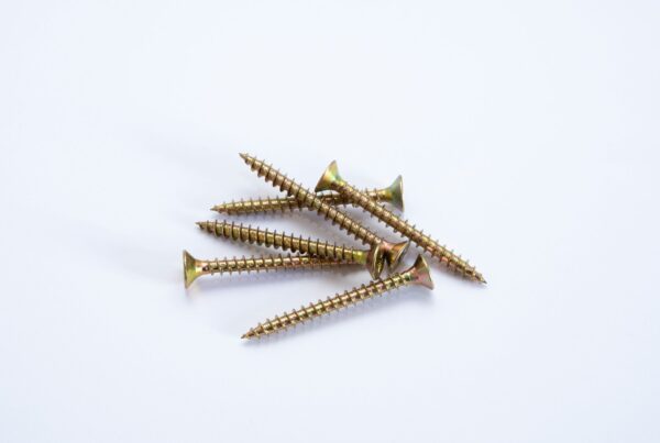 Rows of brass screws laid precisely on stone, representing twenty five small, repeatable AI automations for Alberta businesses