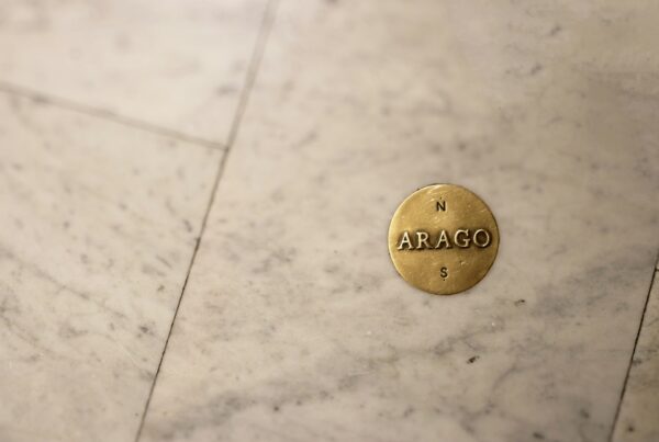 A brass balance scale resting on marble, representing weighing the true cost drivers of AI consulting in Canada