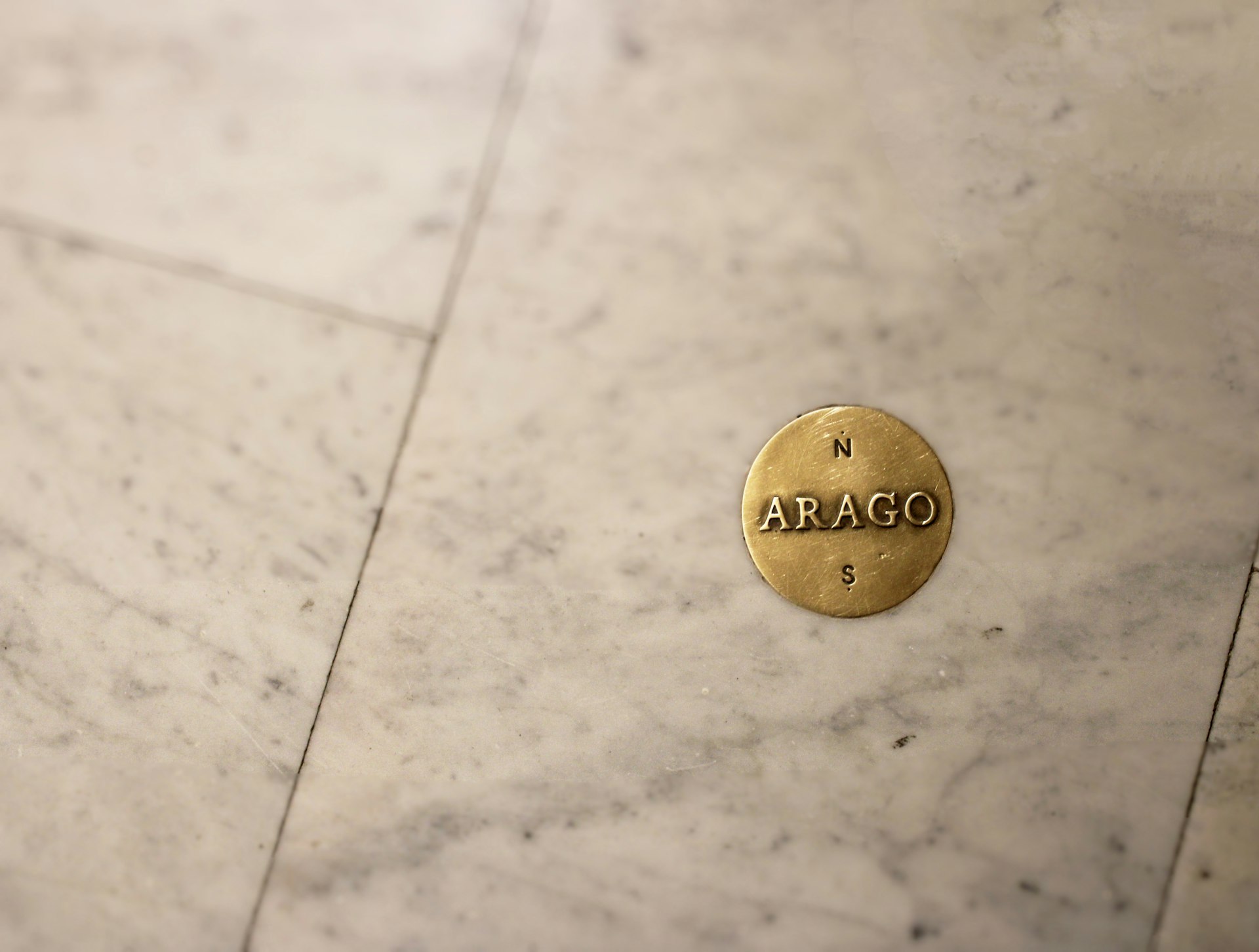 A brass balance scale resting on marble, representing weighing the true cost drivers of AI consulting in Canada