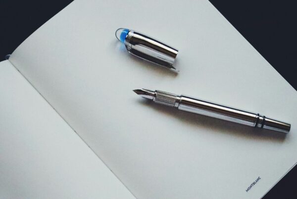 A fountain pen resting on an open ledger page, representing the decisions that should be made before signing off an AI budget line