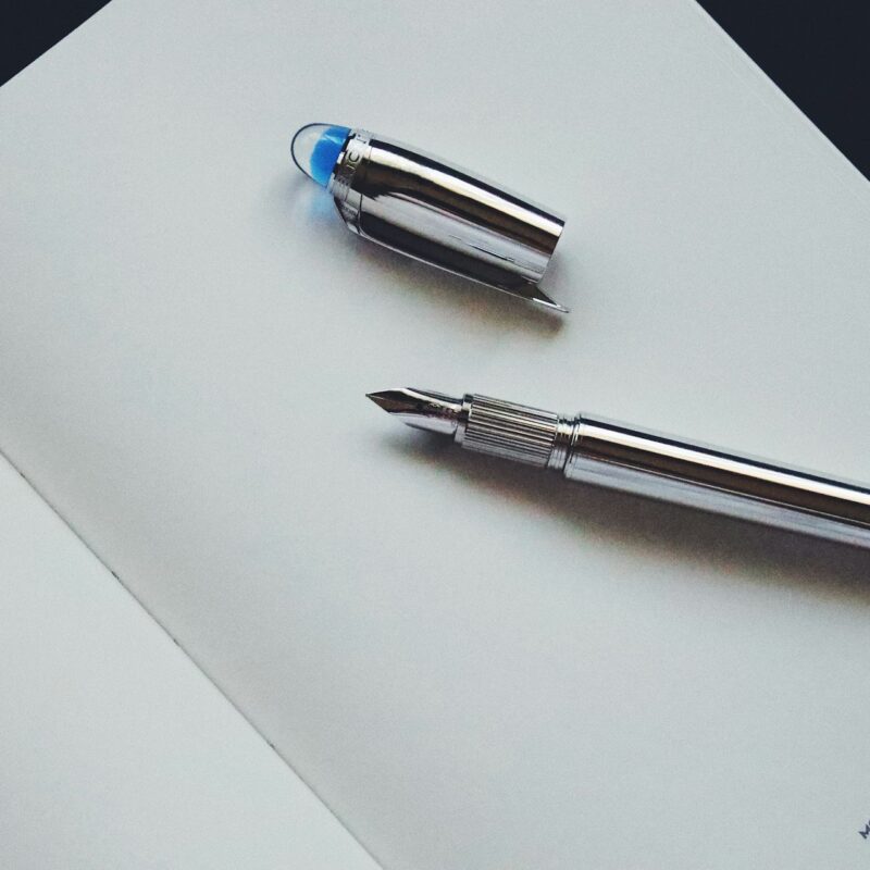 A fountain pen resting on an open ledger page, representing the decisions that should be made before signing off an AI budget line