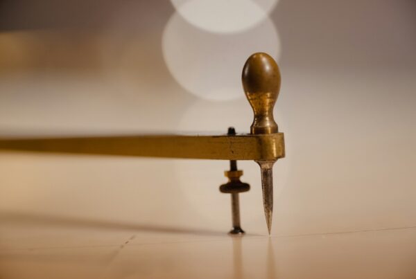 A brass caliper measuring tool on a dark surface, representing scoring business readiness across people, process, data, and leadership