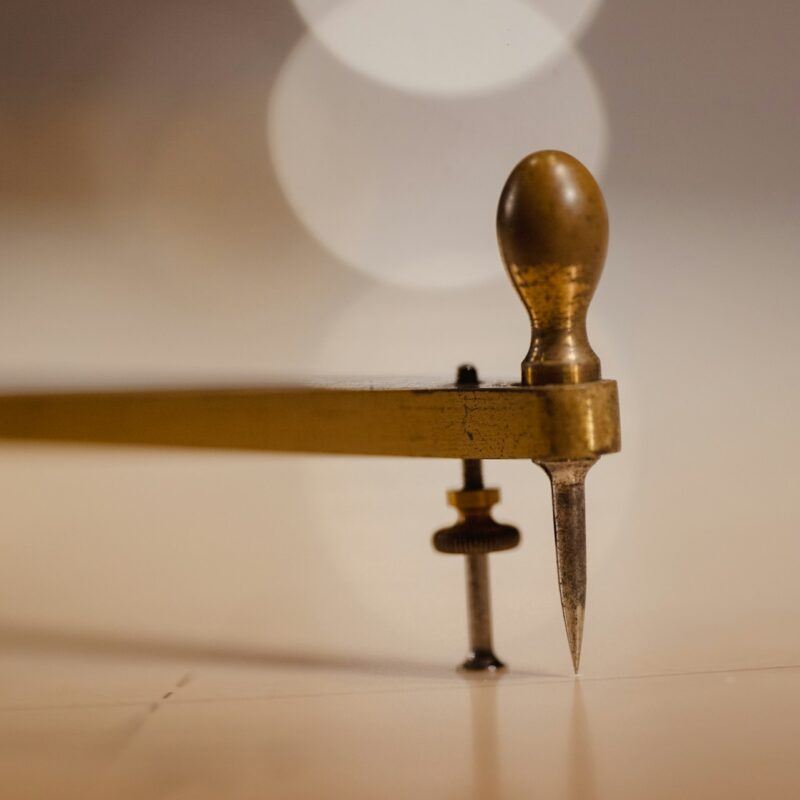 A brass caliper measuring tool on a dark surface, representing scoring business readiness across people, process, data, and leadership
