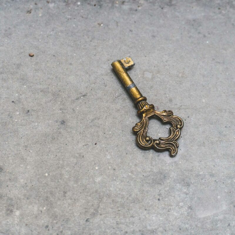 Two brass keys of different complexity resting on marble, representing the choice between a simple chatbot and a more capable AI agent