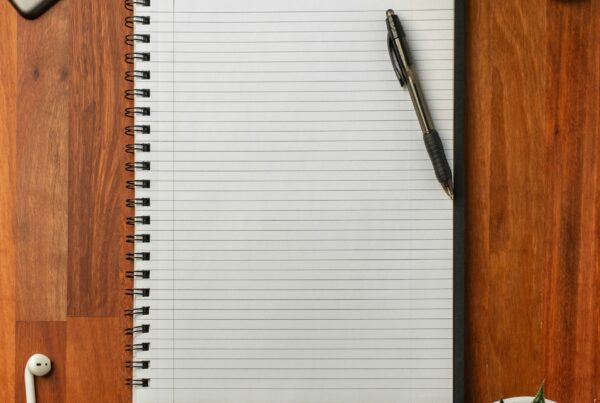 An open notebook and pen on a desk, representing fifteen ChatGPT workflows worth turning into shared company templates