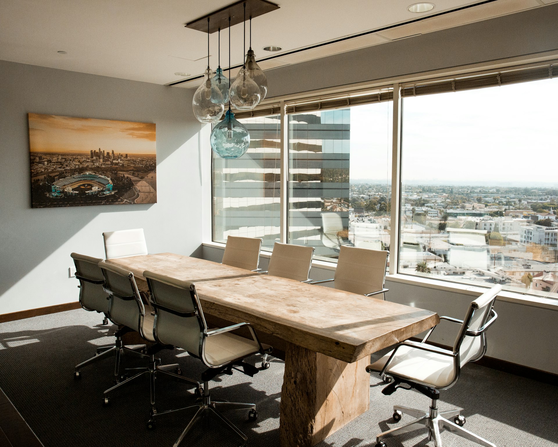 A polished wood boardroom table catching soft morning light, representing the working session where an executive AI workshop produces decisions