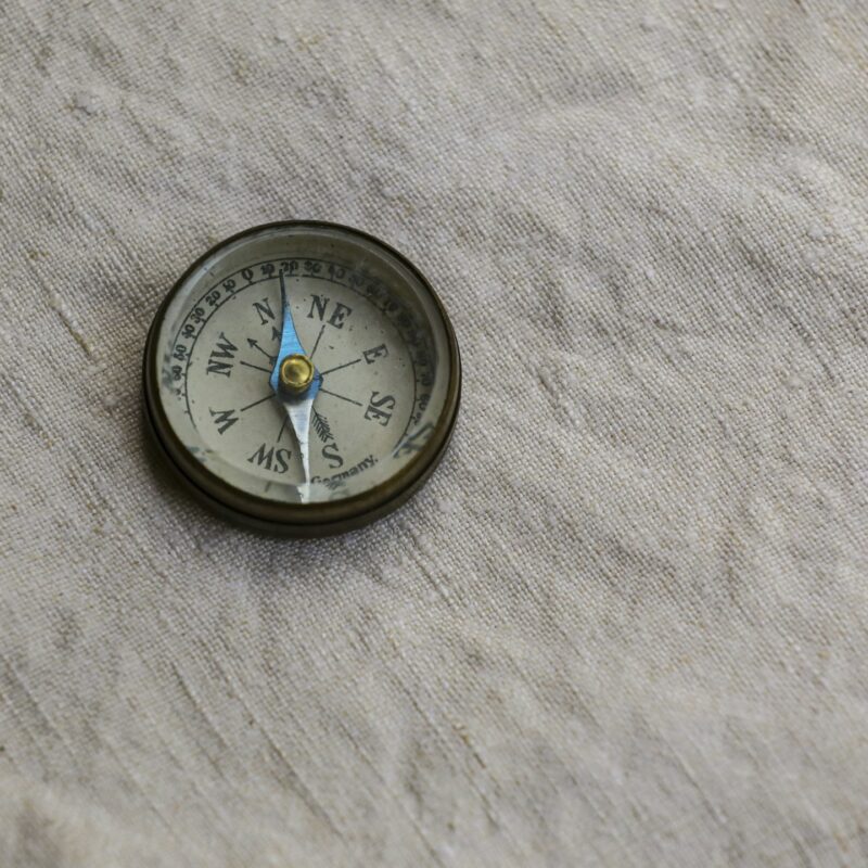 A brass drafting compass resting on paper, representing the precision of building a usable AI roadmap