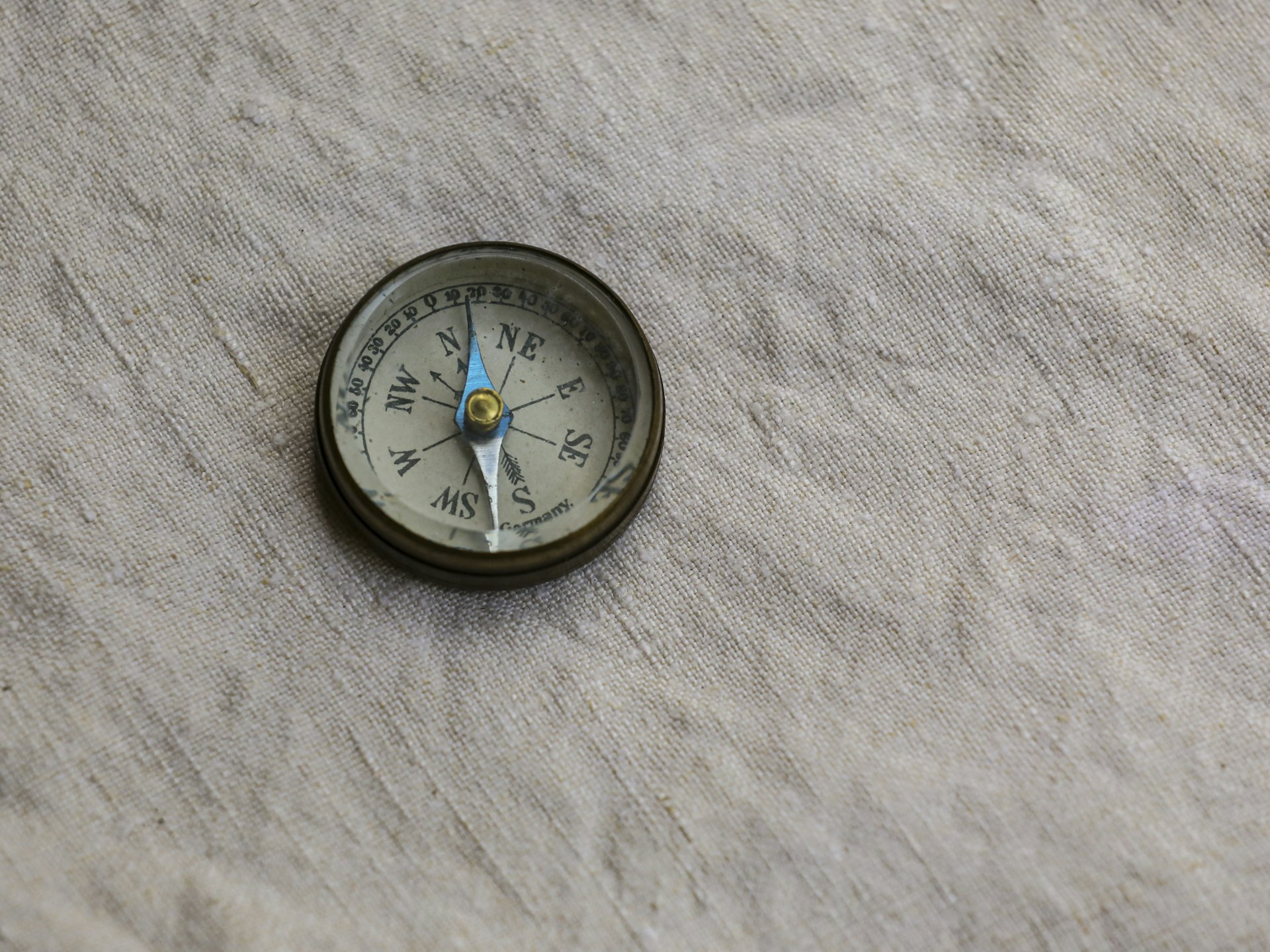 A brass drafting compass resting on paper, representing the precision of building a usable AI roadmap