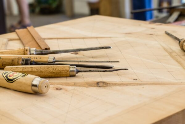 Two pieces of pale oak joined by a hand-cut lap joint, representing bringing a team into an AI change instead of imposing it on them