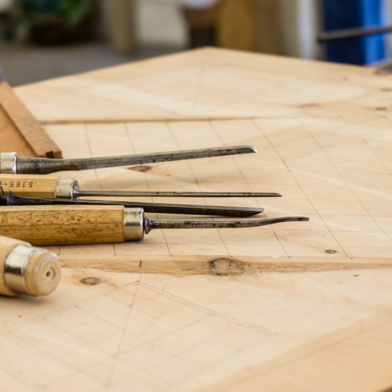 Two pieces of pale oak joined by a hand-cut lap joint, representing bringing a team into an AI change instead of imposing it on them