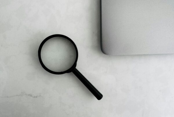A magnifying glass over printed documents, representing an operational audit of business processes before purchasing AI tools