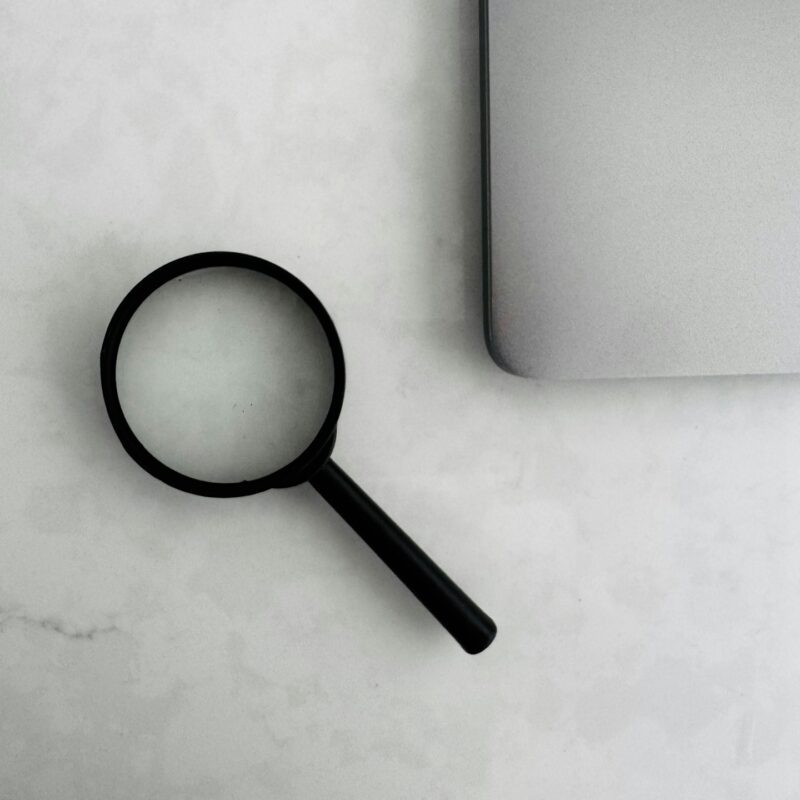 A magnifying glass over printed documents, representing an operational audit of business processes before purchasing AI tools