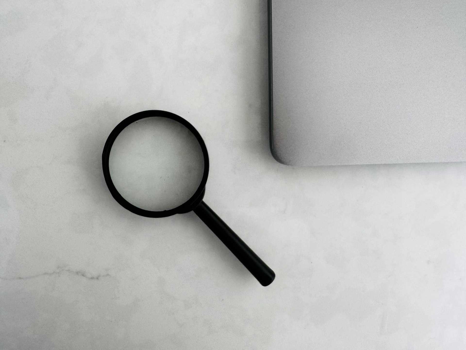 A magnifying glass over printed documents, representing an operational audit of business processes before purchasing AI tools