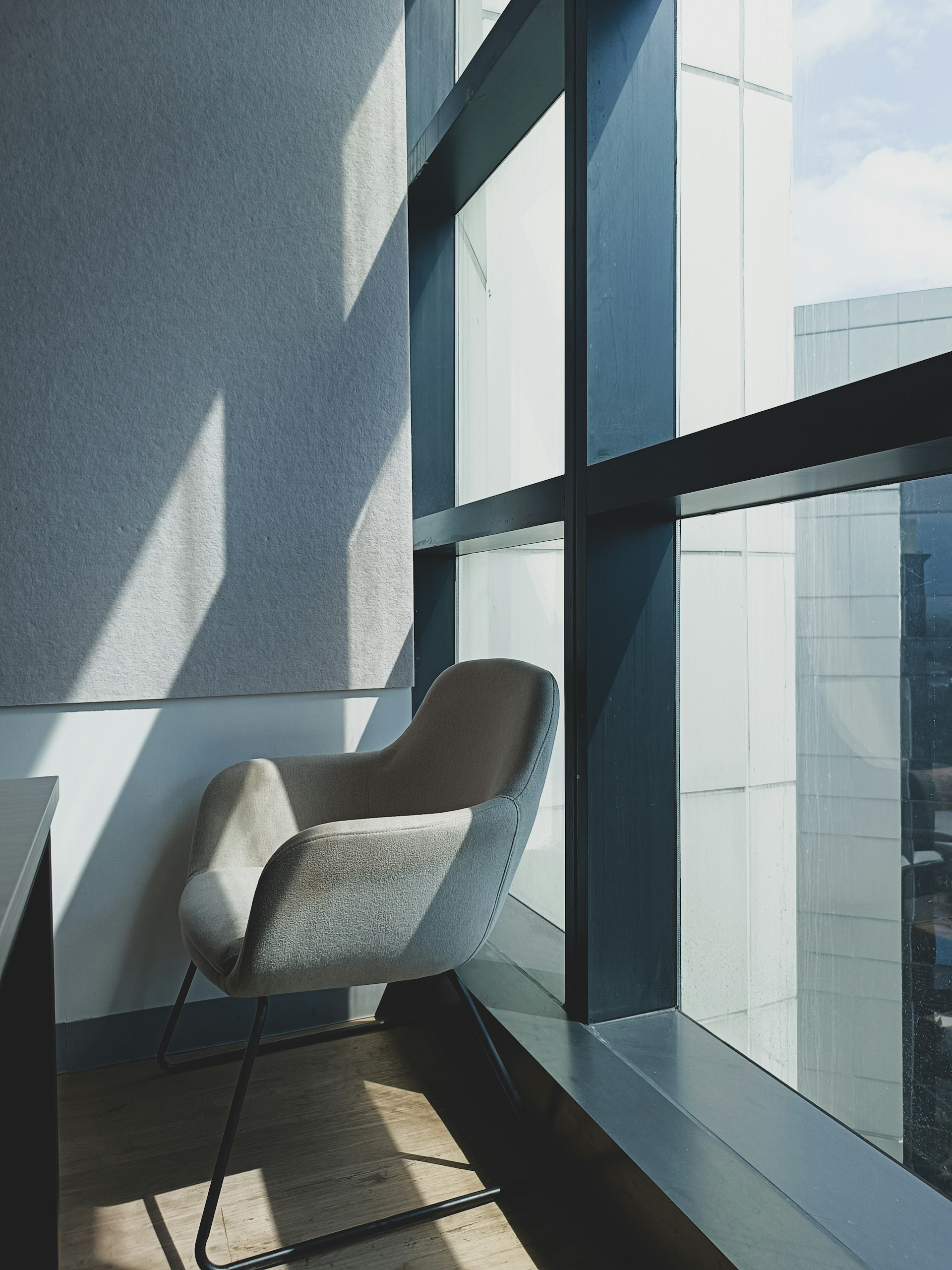 Empty office chairs in soft summer light, representing vacation coverage gaps that AI-assisted workflows can help close