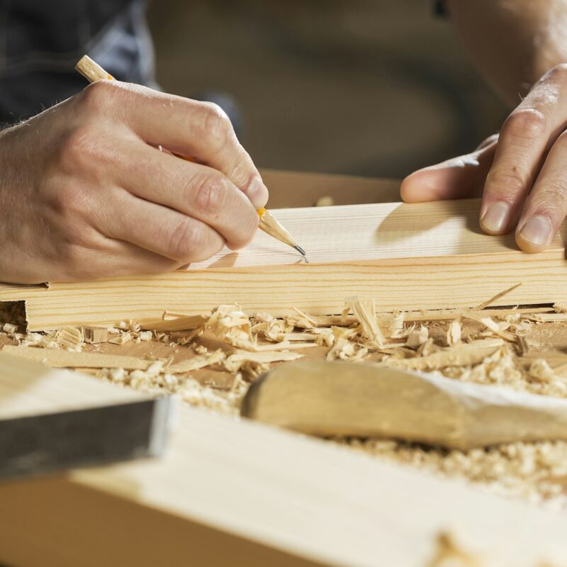 A partially completed dovetail joint in pale wood, representing an AI pilot left unfinished at the handover