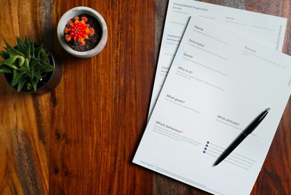 Printed pages and a pen on a wooden desk, illustrating an AI acceptable use policy