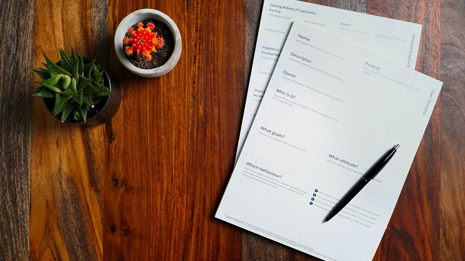 Printed pages and a pen on a wooden desk, illustrating an AI acceptable use policy
