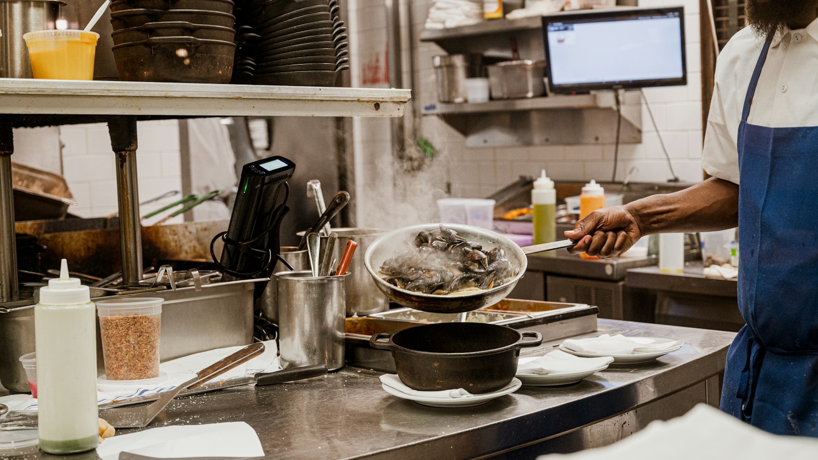 Cook preparing food in a restaurant kitchen, illustrating AI for restaurants