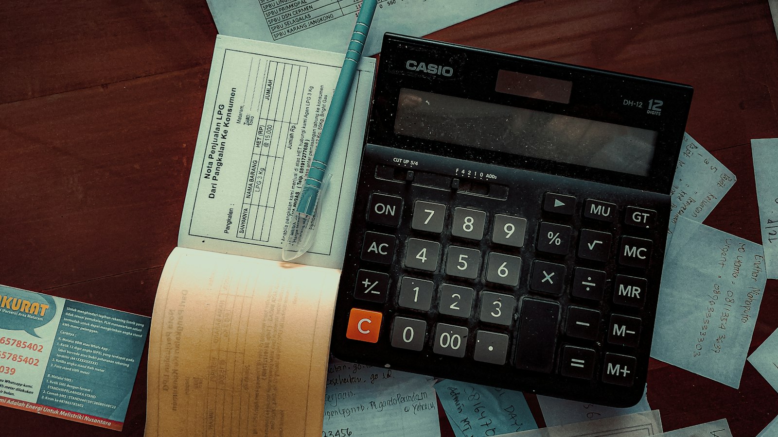 Calculator and receipts on a wooden table, illustrating AI total cost of ownership