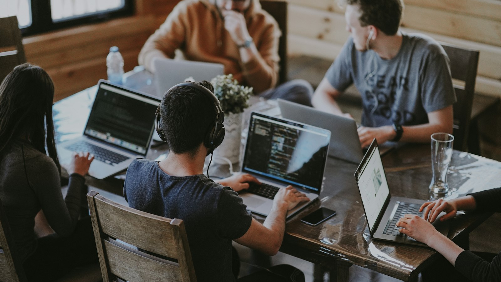 People working on laptops at a shared table, illustrating AI training in Alberta