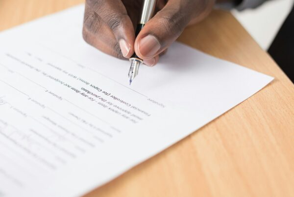 Person signing a contract with a pen, illustrating AI vendor evaluation before signing