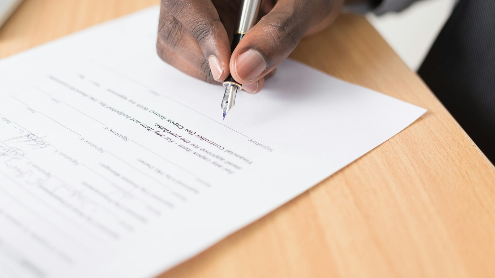 Person signing a contract with a pen, illustrating AI vendor evaluation before signing
