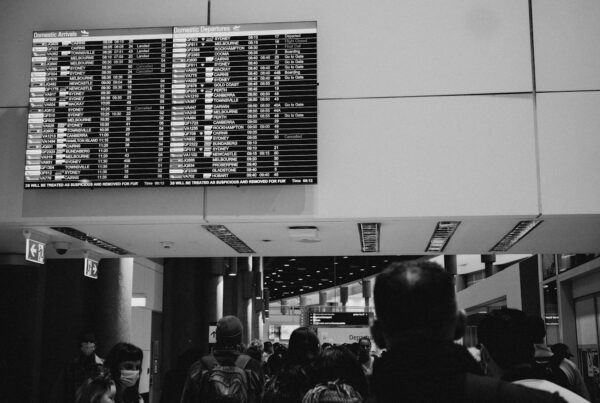 Airport departures board above travellers, illustrating the Air Canada chatbot ruling