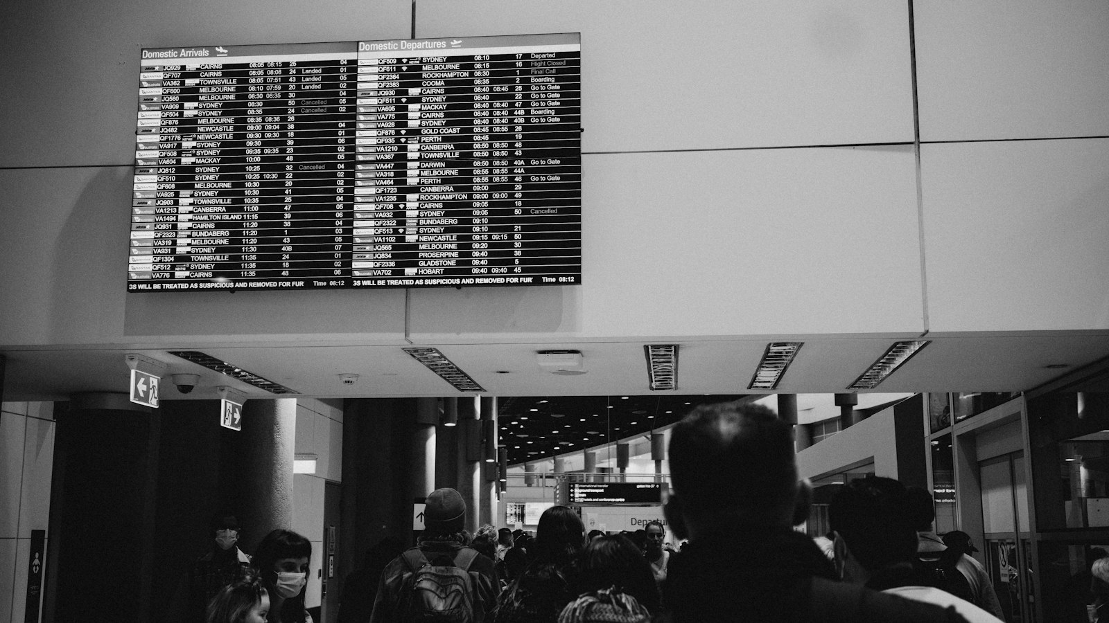 Airport departures board above travellers, illustrating the Air Canada chatbot ruling