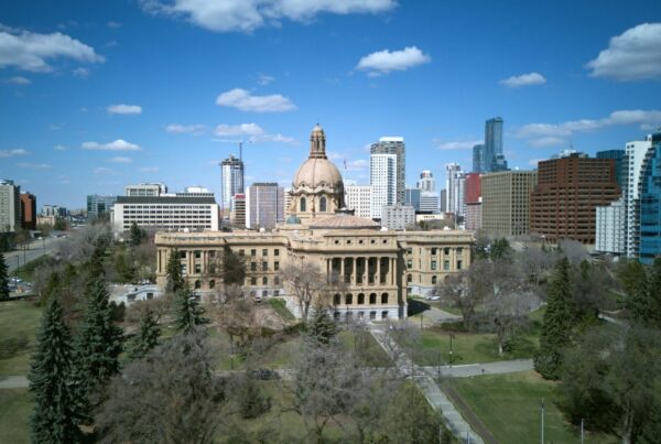 The Alberta Legislature Building in Edmonton with the downtown skyline behind it