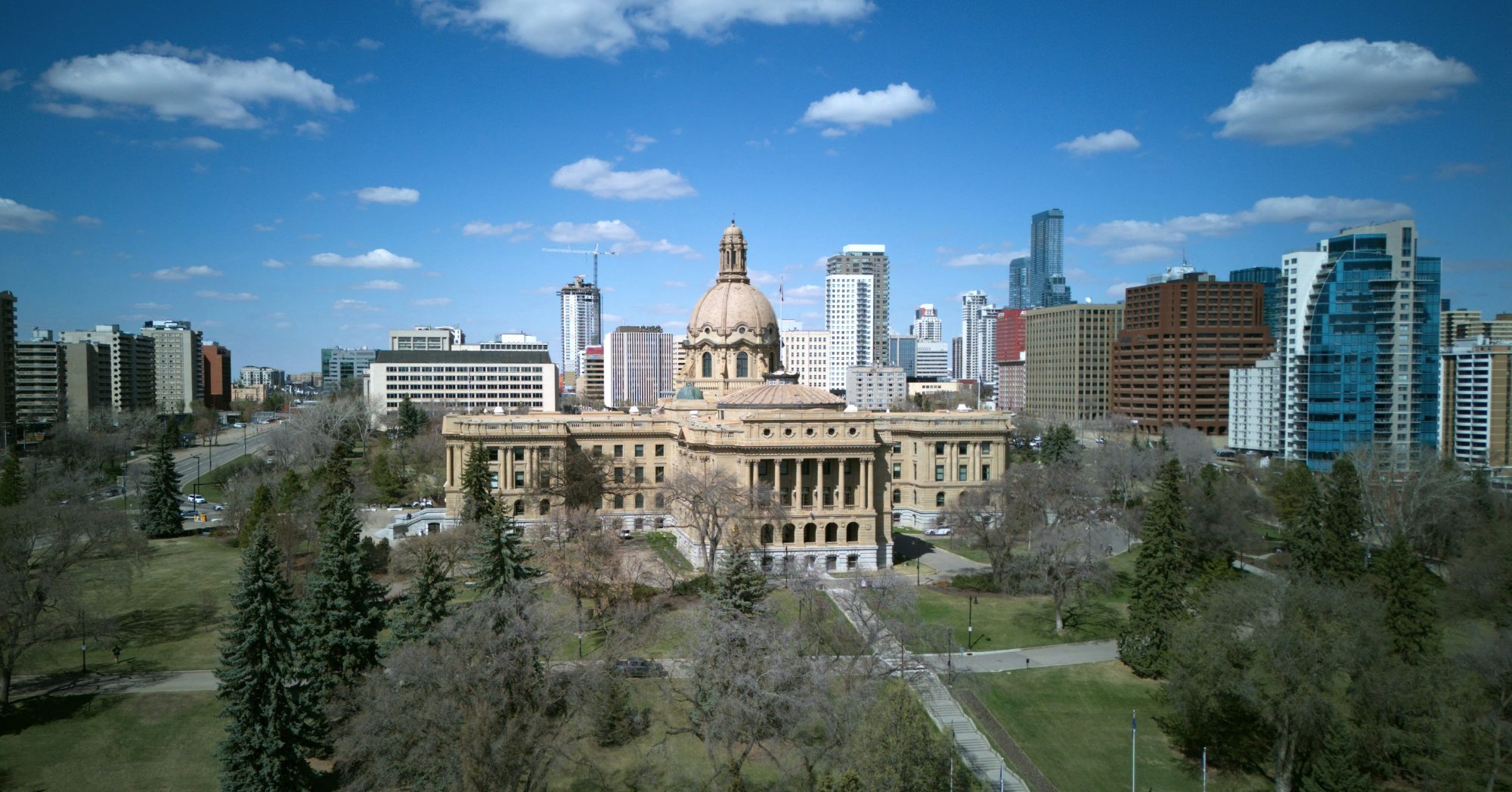 The Alberta Legislature Building in Edmonton with the downtown skyline behind it