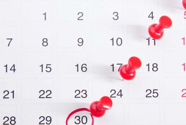 A calendar page with red pins marking dates