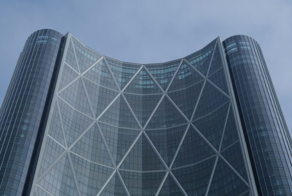 Office tower with a curved glass facade, illustrating the ChatGPT vs Claude vs Copilot choice for business