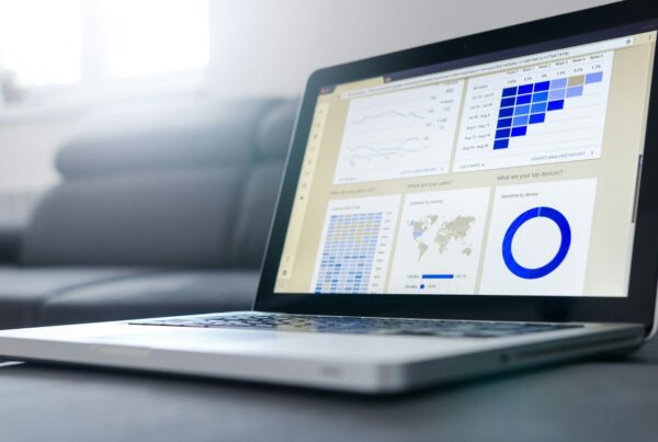 A laptop showing a dashboard of charts
