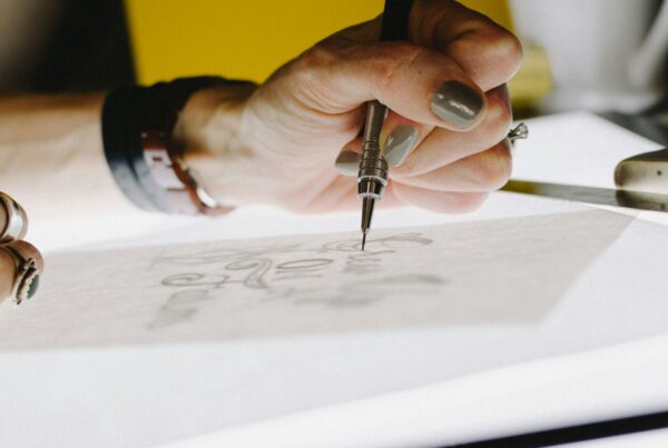 A hand sketching an idea in a notebook