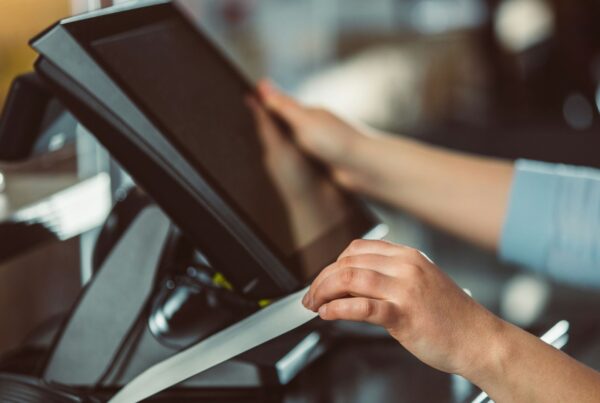 Hands using a point-of-sale terminal at a small business counter