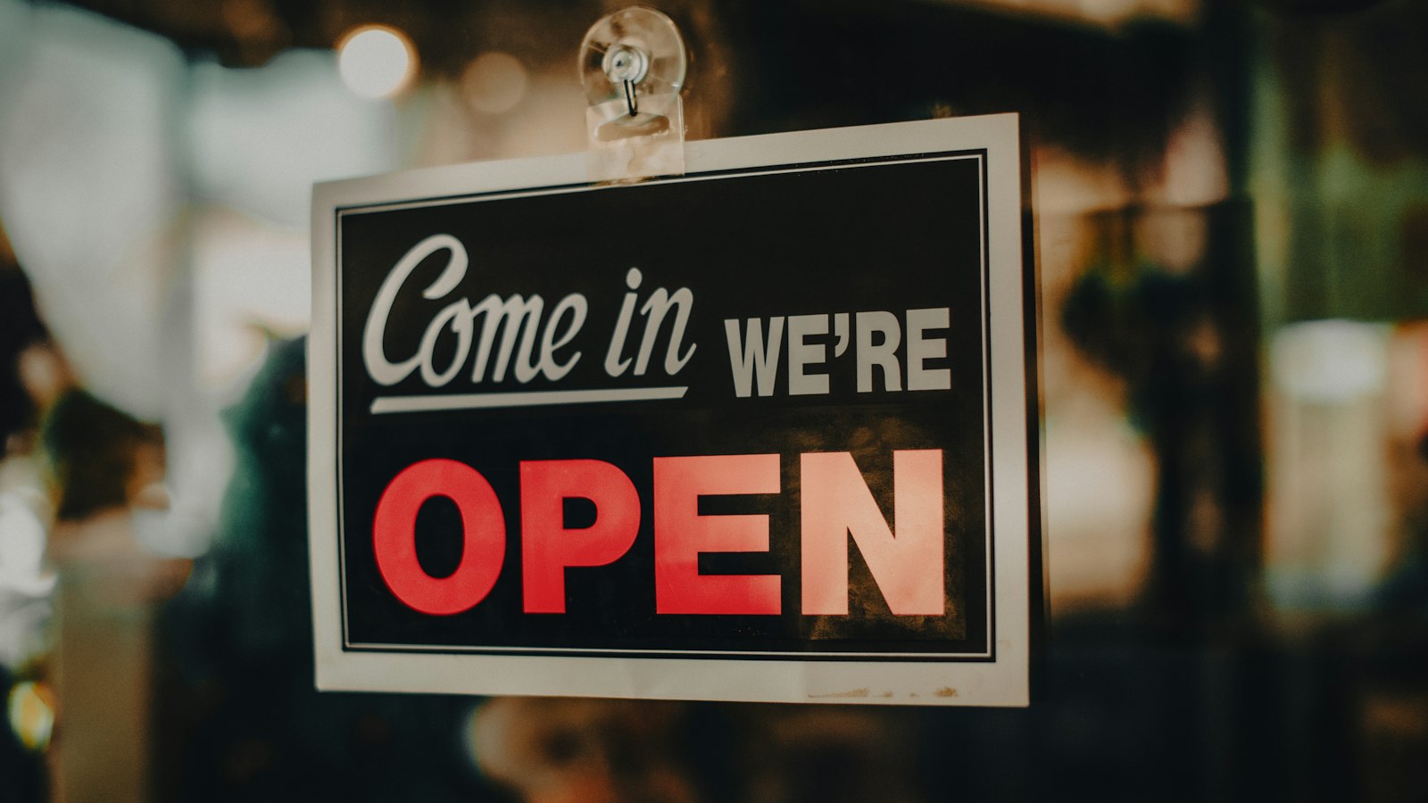 Come in, we're open sign in a shop window, illustrating how a business can show up in AI search
