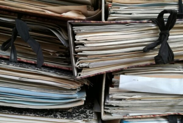 Stacks of paper files piled on office shelves