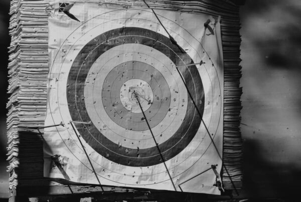 A weathered archery target with arrows landed away from the centre