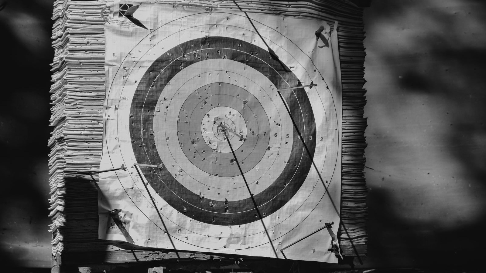 A weathered archery target with arrows landed away from the centre