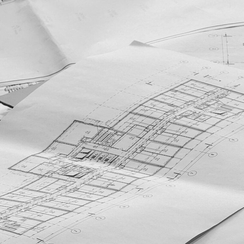 Architectural floor plans spread across a desk