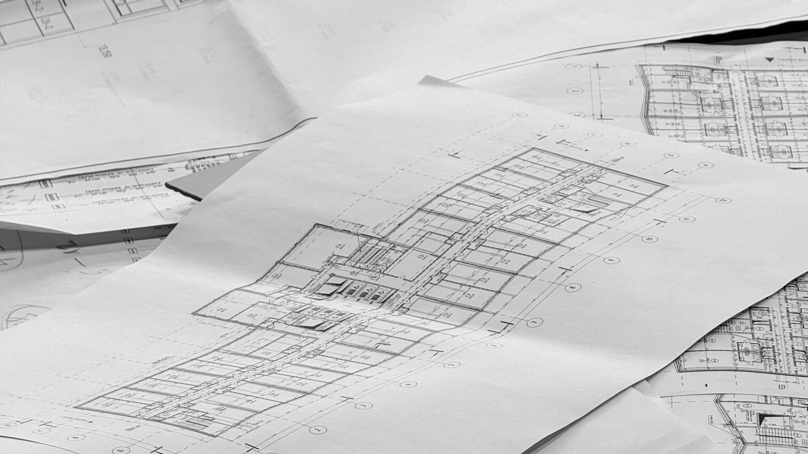 Architectural floor plans spread across a desk