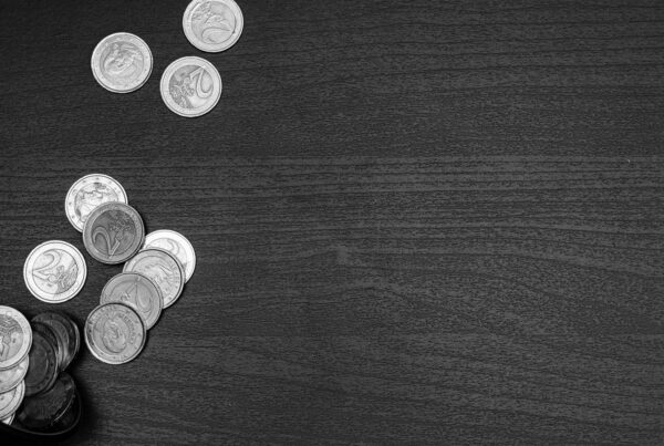 Loose coins in small piles on a dark desk