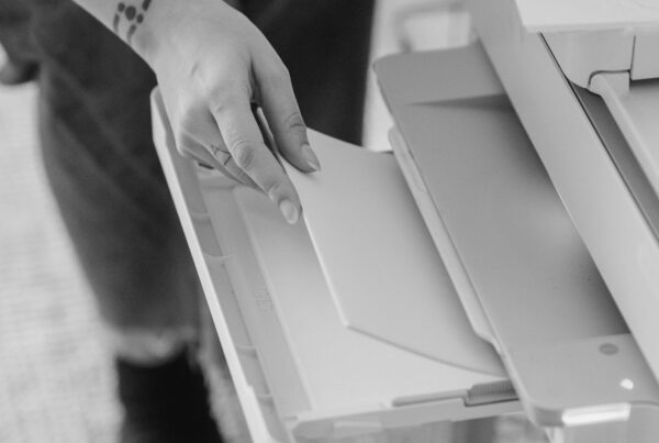 Hand loading a blank page into a printer tray