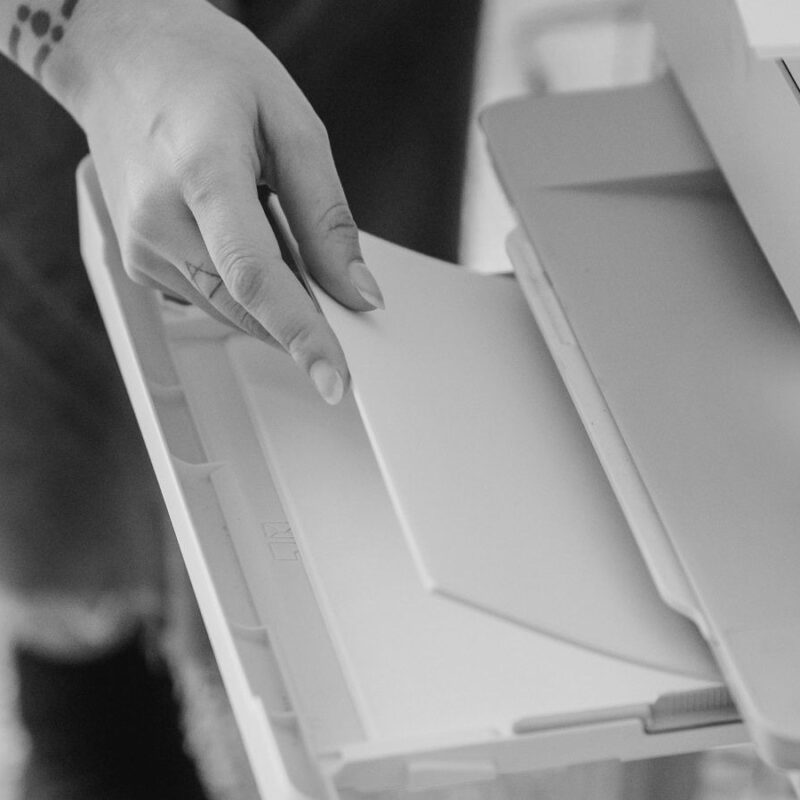 Hand loading a blank page into a printer tray