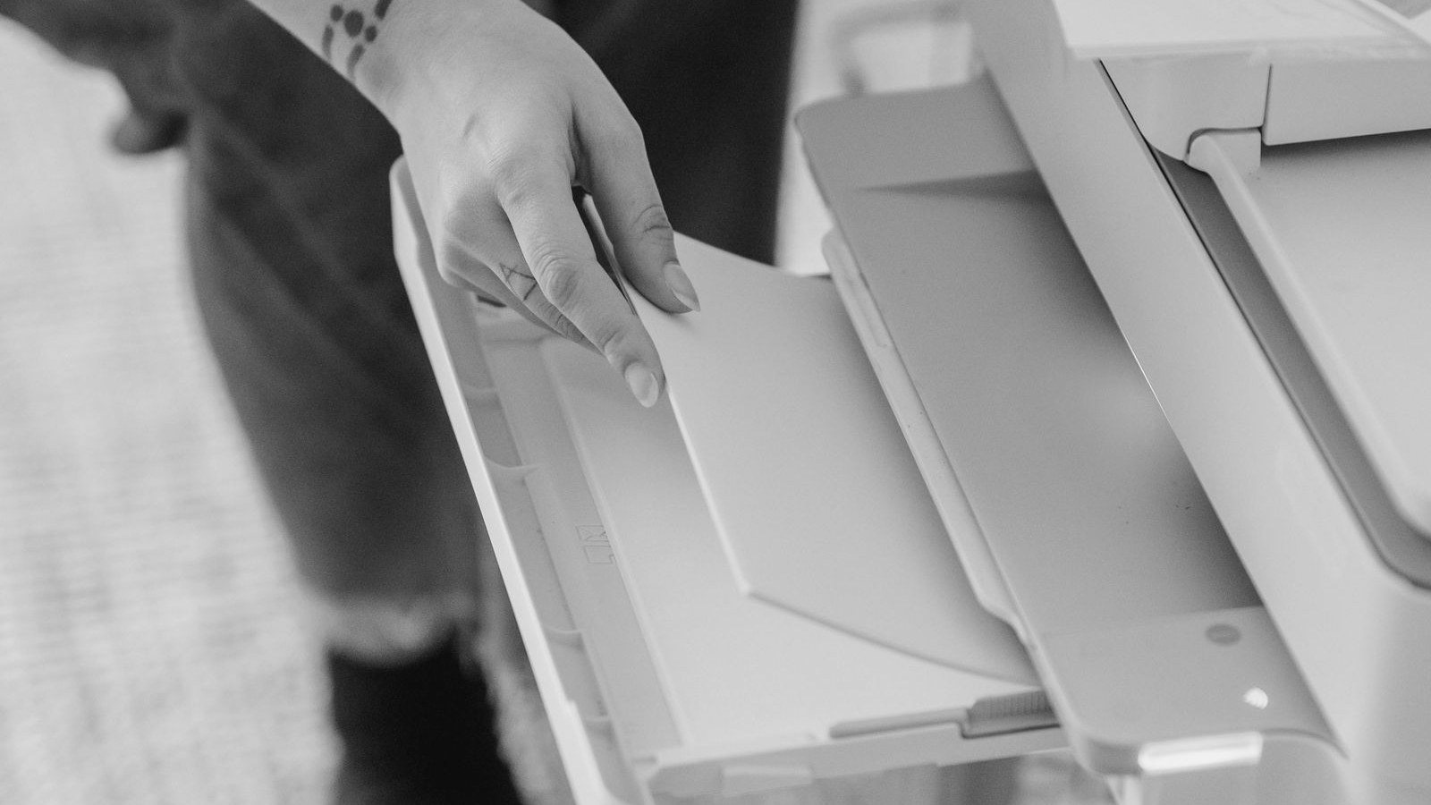 Hand loading a blank page into a printer tray