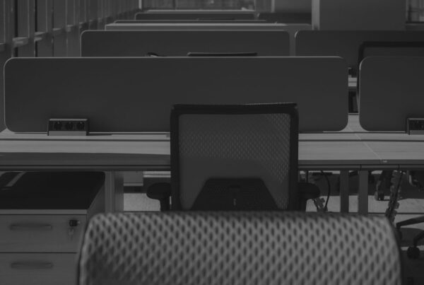 Rows of empty office desks and chairs in a vacant workspace