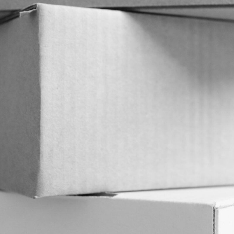 Plain finished mailer boxes stacked on a counter