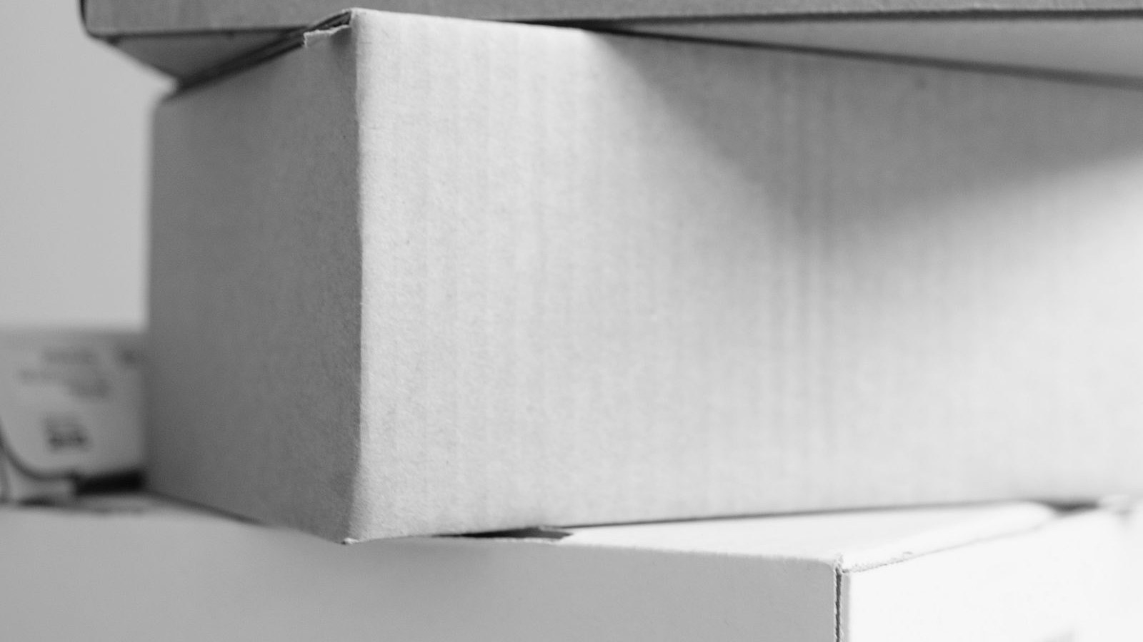 Plain finished mailer boxes stacked on a counter