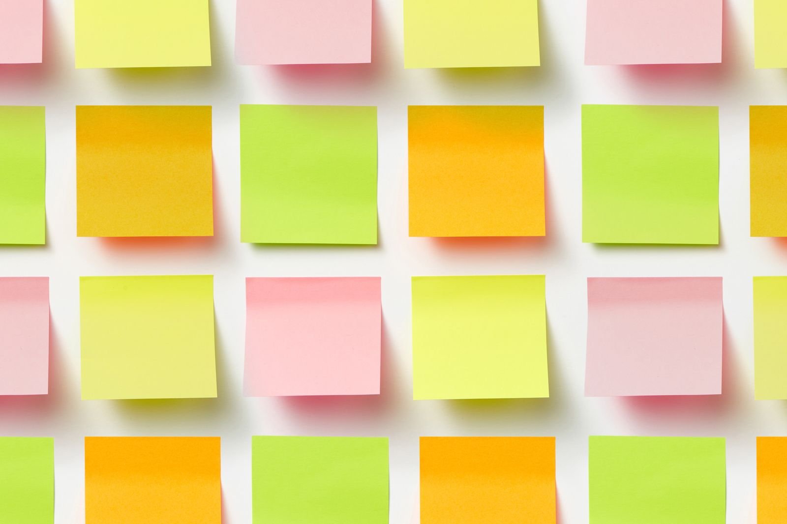 Rows of blank sticky notes lined up on a white board